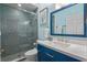 Modern bathroom with blue vanity, marble countertop, glass shower, and stylish fixtures at 219 Isle Of Sky Cir, Orlando, FL 32828