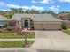 Charming single-story home with a three-car garage, manicured lawn, and beautiful landscaping at 219 Isle Of Sky Cir, Orlando, FL 32828