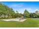Community playground featuring swings, slides, and climbing structures, set in a lush green environment at 219 Isle Of Sky Cir, Orlando, FL 32828