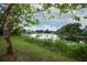 Lush backyard view featuring mature trees and tranquil lake at 2304 Harding Cir, Deltona, FL 32738