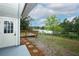 Lake view from backyard featuring a deck, black fence, landscaping stones, and exterior access door at 2304 Harding Cir, Deltona, FL 32738