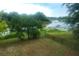 Backyard view of lake with dock, mature trees, and a fenced yard at 2304 Harding Cir, Deltona, FL 32738