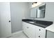 Bathroom featuring gray walls, white cabinets with black pulls, gray counters, and large mirror at 2304 Harding Cir, Deltona, FL 32738