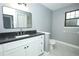 Bathroom featuring gray walls, white cabinets, a black countertop, toilet, and black-framed mirror at 2304 Harding Cir, Deltona, FL 32738