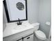 This bathroom features a vanity with modern fixtures, an octagonal mirror, and white toilet at 2304 Harding Cir, Deltona, FL 32738