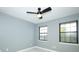 Bedroom with light-gray walls, two windows with black frames, ceiling fan, and light vinyl wood flooring at 2304 Harding Cir, Deltona, FL 32738