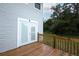 Spacious deck with glass paneled exterior door and wood railing with view of fenced yard and wooded area at 2304 Harding Cir, Deltona, FL 32738