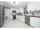 Bright kitchen featuring subway tiles, stainless steel appliances, and white cabinets with black hardware at 2304 Harding Cir, Deltona, FL 32738