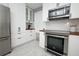 This charming kitchen features stainless steel appliances, white subway tiles, and stylish white cabinetry at 2304 Harding Cir, Deltona, FL 32738