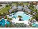Community clubhouse and swimming pool area with seating, mature landscaping, circular driveway and ample parking at 2515 Dharma Cir, Kissimmee, FL 34746