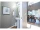 Bathroom featuring a pedestal sink, framed floral art, and view into the dining area at 2515 Dharma Cir, Kissimmee, FL 34746