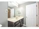 Bathroom featuring tile floors, a dark wood vanity with a sink, a white door, and a large mirror for extra light at 2515 Dharma Cir, Kissimmee, FL 34746