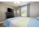 Bedroom with ceiling fan, flat screen TV, wood floors, and bright window at 2515 Dharma Cir, Kissimmee, FL 34746