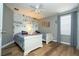 Cozy bedroom offering hardwood floors, comic themed wallpaper, and light from the large window at 2515 Dharma Cir, Kissimmee, FL 34746