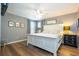 This bedroom features hardwood floors, a ceiling fan, and a bright white bed frame with end tables and lamps for extra light at 2515 Dharma Cir, Kissimmee, FL 34746
