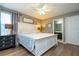 This bedroom features hardwood floors, a ceiling fan, white bed frame, and an ensuite bathroom with a dark wood vanity at 2515 Dharma Cir, Kissimmee, FL 34746