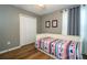 Charming bedroom featuring wood floors, a closet, and a twin bed with colorful patterned bedding at 2515 Dharma Cir, Kissimmee, FL 34746