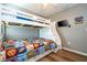 This cozy bedroom features hardwood floors, a ceiling fan, TV, and a bunk bed with pull out drawers for additional storage at 2515 Dharma Cir, Kissimmee, FL 34746
