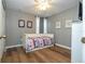Bright bedroom with hardwood floors, white trim, ceiling fan, curtains, and a white daybed with a colorful patterned quilt at 2515 Dharma Cir, Kissimmee, FL 34746