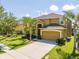 Inviting curb appeal with a well-maintained lawn, palm trees, and a spacious driveway leading to an attached garage at 2515 Dharma Cir, Kissimmee, FL 34746