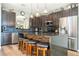 Bright kitchen with granite countertops, island seating, dark cabinets, and stainless steel appliances at 2515 Dharma Cir, Kissimmee, FL 34746