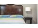 Main bedroom features wood headboard, bedside table, and decorative lamp at 2515 Dharma Cir, Kissimmee, FL 34746