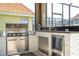Covered outdoor kitchen with stainless steel grill, mini fridge and stacked stone facade at 2515 Dharma Cir, Kissimmee, FL 34746