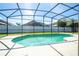 Screened-in kidney shaped pool with concrete surround, grassy area and fenced yard at 2515 Dharma Cir, Kissimmee, FL 34746