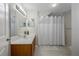 Clean bathroom with a white shower curtain, wood vanity, and ample lighting at 2605 Gala S Rd # 106, Kissimmee, FL 34746
