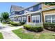 Townhome exterior showcasing colorful facade, white picket fence, and manicured green landscaping at 2605 Gala S Rd # 106, Kissimmee, FL 34746