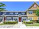 Charming townhome featuring a red front door, white picket fence, and well-manicured landscaping at 2605 Gala S Rd # 106, Kissimmee, FL 34746