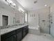 Bathroom featuring a double vanity with granite countertop, soaking tub and walk-in shower with glass door at 2621 Peony Dr, Oviedo, FL 32766