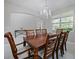 Formal dining room with a wooden table, chandelier, and large windows that bring in natural light at 2621 Peony Dr, Oviedo, FL 32766