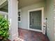 Covered entrance with brick flooring, dark green front door, and a decorative welcome sign at 2621 Peony Dr, Oviedo, FL 32766