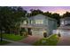 Inviting two-story home featuring a manicured lawn, paver driveway, and attached two-car garage at 2621 Peony Dr, Oviedo, FL 32766