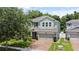Inviting two-story home with a brick driveway and lush, green landscaping and a two car garage at 2621 Peony Dr, Oviedo, FL 32766