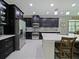 Spacious kitchen with stainless steel appliances, dark cabinetry, and a large center island at 2621 Peony Dr, Oviedo, FL 32766