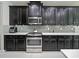 Modern kitchen featuring dark cabinetry, stainless steel appliances, and white countertops at 2621 Peony Dr, Oviedo, FL 32766