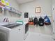 Laundry room featuring a washer and dryer, storage shelves, and hooks for organization, offering practicality at 2621 Peony Dr, Oviedo, FL 32766