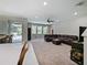 Open living room with carpet, leather sectional, and access to the outdoor pool area at 2621 Peony Dr, Oviedo, FL 32766