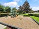A colorful community playground with slides, climbing structures, and a wood chip safety surface, surrounded by lush landscaping at 2621 Peony Dr, Oviedo, FL 32766