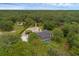 Aerial view showing the house, a long driveway, and surrounding wooded property at 2630 S Tanner Rd, Orlando, FL 32820