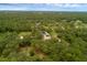 An aerial image displays a home surrounded by verdant forest, underscoring its privacy and natural setting at 2630 S Tanner Rd, Orlando, FL 32820