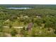 Expansive aerial view of a single-Gathering home surrounded by lush greenery and a picturesque lake backdrop at 2630 S Tanner Rd, Orlando, FL 32820