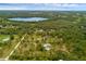An aerial view showcases a home embraced by a forest and lake, set in a serene and private location at 2630 S Tanner Rd, Orlando, FL 32820