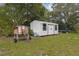 A backyard with a chicken coop, metal shed, trampoline, and trees at 2630 S Tanner Rd, Orlando, FL 32820