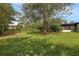 A spacious backyard with a lawn, trees, and a screened-in porch at 2630 S Tanner Rd, Orlando, FL 32820