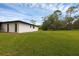 A spacious backyard with a lawn and the side of the house at 2630 S Tanner Rd, Orlando, FL 32820