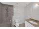 Bathroom featuring tiled walk-in shower, toilet, and a single sink vanity at 2630 S Tanner Rd, Orlando, FL 32820