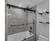 Bathroom featuring tub-shower combo with black hardware and tiled walls at 2630 S Tanner Rd, Orlando, FL 32820